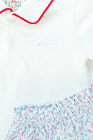 Close up of embroidered paper airplane on boy’s pima cotton polo shirt.