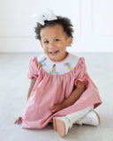 girl wearing smocked circus animals dress