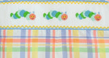 Close up of colorful caterpillars on a fun back to school plaid fabric.