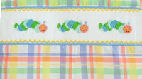 Close up of colorful caterpillars on a fun back to school plaid fabric.