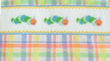 Close up of colorful caterpillars on a fun back to school plaid fabric.