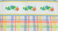 Close up of colorful caterpillars on a fun back to school plaid fabric.