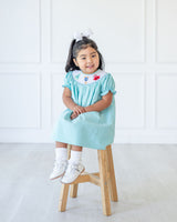 GIRL WEARING SMOCKED MONSTERS DRESS 