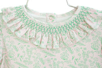 close up of ruffle on pink and green floral girl's outfit