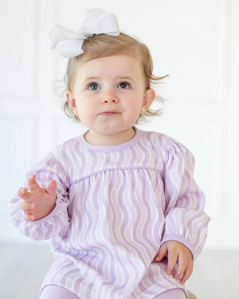 girl wearing purple top and leggings play set