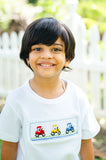 Boy smiling in Smocked Tractor T-Shirt by Ruth and Ralph, close-up view of smocked embroidery design