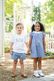 Boy and girl in matching Ruth and Ralph smocked hunting outfits holding hands outdoors near white picket fence