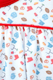 Girl's white game day dress with football and tailgate print, styled with pom-poms and a football for game day
