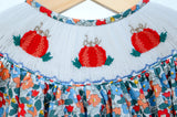 Close-up of smocked pumpkin embroidery detail on Ruth and Ralph blue floral dress