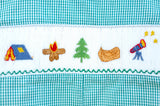 Close-up of smocked camping embroidery detail on Ruth and Ralph teal gingham Bubble, featuring tent, campfire, tree, and canoe