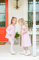 A little girl wearing the Pink Bow Shirt & Leggings Set is ready for a day of fun, whether playing at home or out for a casual outing.