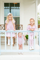 A little girl wearing the Pink Bow Pima Dress with a beautiful pink bow pattern looks absolutely charming and stylish in this soft, elegant outfit.