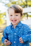 A little boy wearing the Blue Bandana Print Conrad Button-Up Shirt looks effortlessly stylish in this charming, western-inspired shirt.