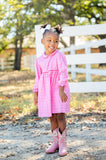 A little girl wearing the Pink Bandana Print Pima Libby Dress enjoys the lightweight feel and breathable fabric, ideal for any occasion.