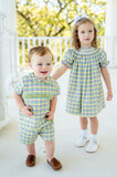 The vibrant plaid of the smocked Mardi Gras short set captures the spirit of Mardi Gras, making it a standout choice.