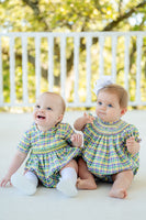 Two babies in a festive smocked bubble featuring classic Mardi Gras colors and plaid design