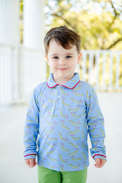 A little boy wearing the Lovely Caterpillars Shep Polo Long Sleeve Shirt looks absolutely adorable in this playful design featuring all-over caterpillars and hearts on a soft blue background.