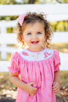 A little girl wearing the Smocked Pink Bandana and Boots Rodeo Annabelle Bloomer Set enjoys the comfort of the soft cotton fabric, perfect for all-day wear.