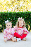 A little girl sitting down in the Lovely Butterflies Top and Leggings Set.