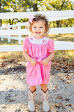 A little girl wearing the smocked Bandana and Boots Rodeo Helen Dress looks picture-perfect for events, outings, or family photos.