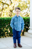 A little boy wearing the Blue Bandana Print Conrad Button-Up Shirt stands out with its unique, yet timeless pattern.