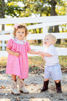 The classic smocking paired with playful western details makes this dress a standout choice for your little one.