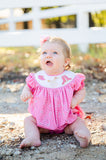 A little girl wearing the Smocked Bandana and Boots Rodeo Birdie Bubble enjoys its soft cotton fabric, ensuring all-day comfort.