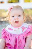 A little girl wearing the Smocked Bandana and Boots Rodeo Birdie Bubble looks absolutely adorable in this western-inspired outfit.