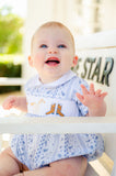 A little baby boy wearing the smocked Bandana and Boots Rodeo Henry Bubble in blue is sure to steal hearts with his charming, stylish look.