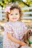 A little girl wearing the Smocked Cowgirl Toile Helen Dress will capture everyone’s attention with her adorable look and western charm.