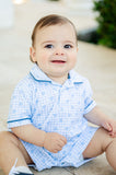 A little boy is wearing the Blue Hearts Plaid Boys Pima Romper, featuring a classic blue plaid design with heart accents.