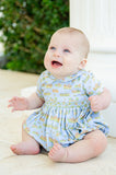 A baby boy wearing the Smocked Cowboy Toile Arthur Bubble in light blue looks absolutely adorable in this western-inspired outfit.