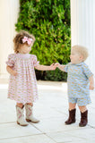 A little boy wearing the Smocked Cowboy Toile Samuel Shirt/Shorts Set will love the cowboy toile details that give it a fun and rustic feel.