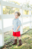 A little boy wearing the Blue Cowboy Toile Conrad Button-Up Shirt is sure to capture attention with its unique and stylish western details.