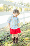 A little boy wearing the Blue Cowboy Toile Conrad Button-Up Shirt is ready for family gatherings, playdates, or special outings with its western-inspired style.