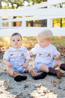 A little boy sitting in the Bandana and Boots Rodeo Benjamin Jonjon looks picture-perfect with the unique combination of boots and bandana print.