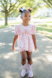 A girl wearing the Pink Cowgirl Toile Pima Mary Bloomer Set will love the playful cowgirl toile print, featuring western motifs on a soft pink background.