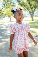 A girl wearing the Pink Cowgirl Toile Pima Mary Bloomer Set stands out with its charming design and soft, pink tones.