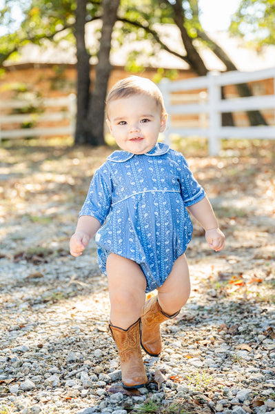 A toddler boy wearing the Blue Bandana Print Pima Alexander Bubble looks absolutely charming in this stylish, playful outfit.