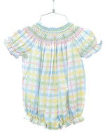 The little girl is wearing the Pastel Smocked Easter Plaid Bubble, and its soft, pastel colors are perfect for Easter and spring celebrations.