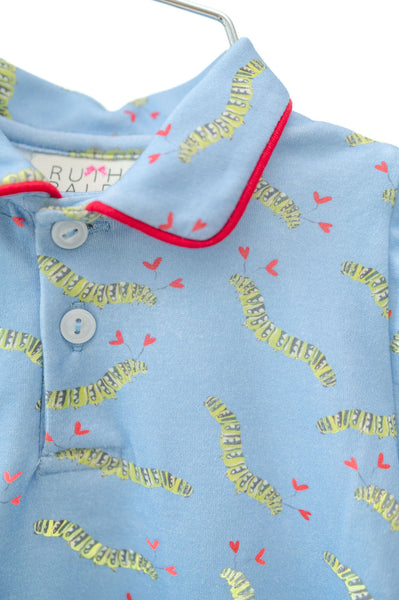 A baby boy is wearing the Caterpillar Hearts Boys Pima Romper, showcasing a playful caterpillar heart pattern on a soft blue background.