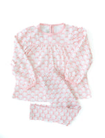 The shirt features a beautiful pink bow pattern, adding a sweet touch to the soft, pastel pink fabric.