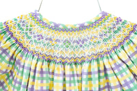 The smocked dress features a vibrant green, yellow, and purple plaid design, making it ideal for Mardi Gras celebrations.