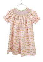 The dress features delicate smocked detailing, adding a touch of elegance while maintaining a playful and stylish look.