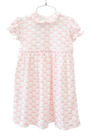 The dress features a beautiful bow pattern that adds a timeless charm to the soft pink fabric.