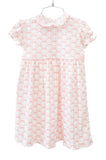 The dress features a beautiful bow pattern that adds a timeless charm to the soft pink fabric.