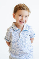 The Playful Bunnies Pima Shep Polo for toddlers and young boys features a fun bunny print with white bunnies outlined in blue, complete with blue piping.