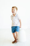 A little boy wearing the Puppies Pima Short Set with blue piping and blue shorts looks stylish and ready for spring.