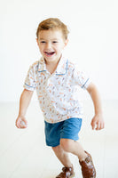 Whether at the park or a family gathering, a little boy wearing the Puppies Pima Short Set with blue piping and blue shorts stands out with ease.