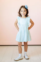 A little girl wearing the Blue Striped Dress with ruffle details will shine this spring at any special occasion.